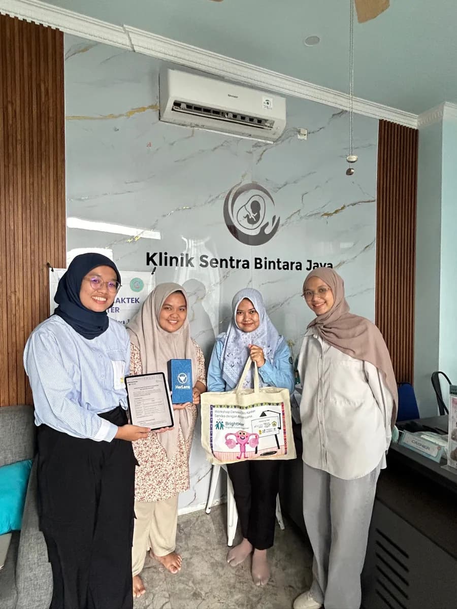 Tim HerLens bersama staf Klinik Sentra Bintara Jaya, memegang kit HerLens