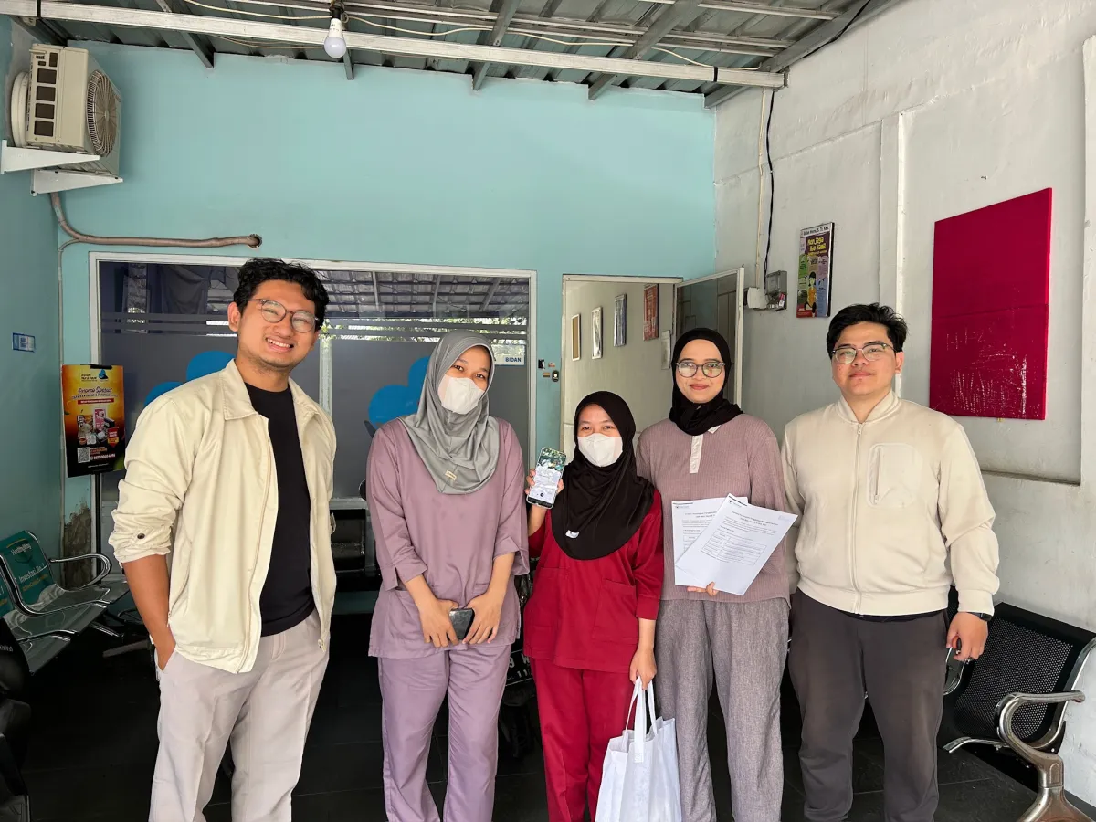 Tim HerLens bersama staf klinik yang memegang materi HerLens
