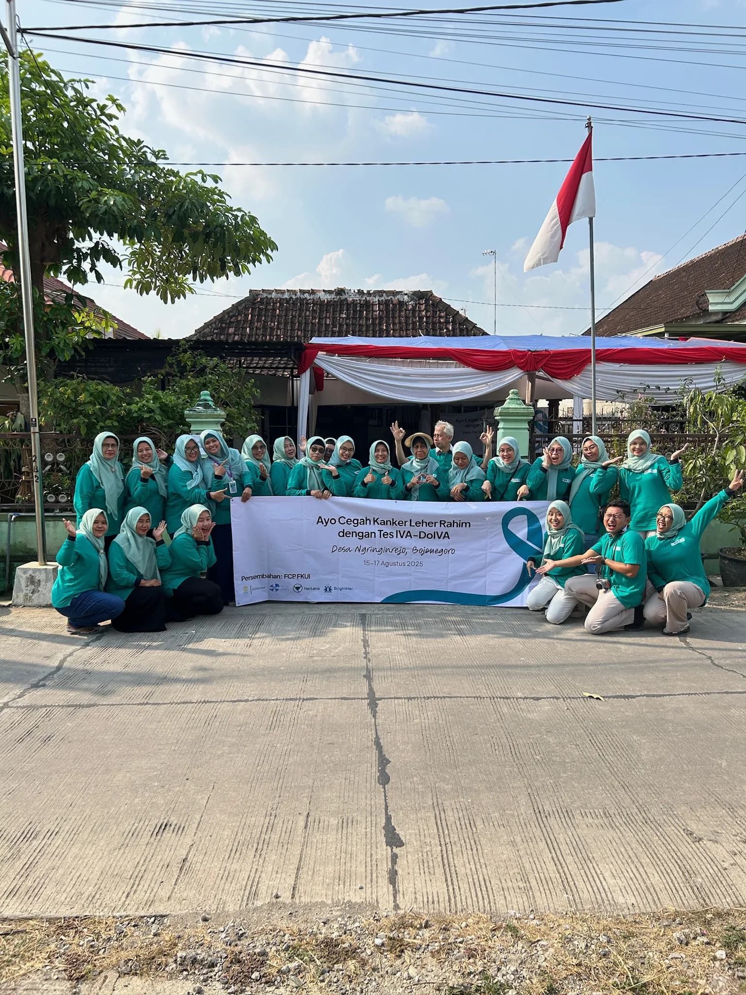 Tenaga kesehatan berseragam hijau toska berfoto bersama spanduk kampanye skrining kanker serviks di Bojonegoro